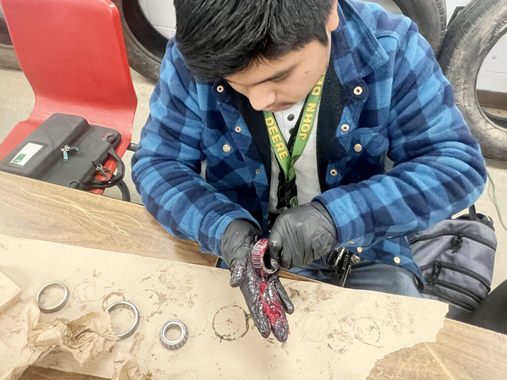 automotive student greasing bearings