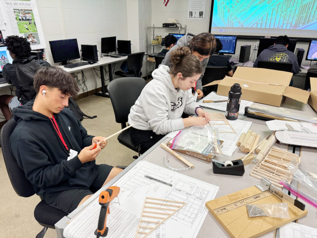 students working on project with kits and blueprints